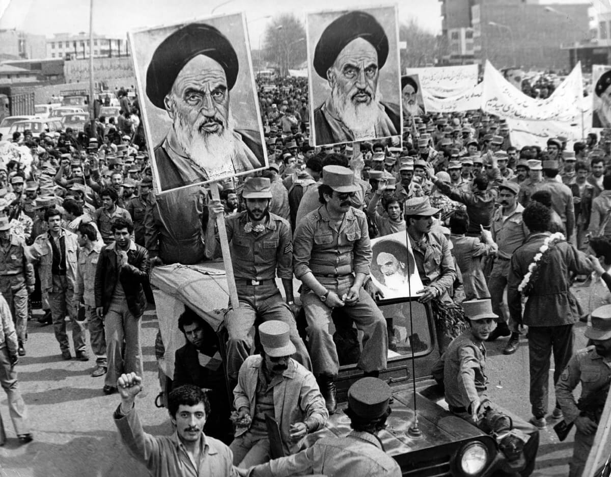 1979 İran devrimi sırasında sokaktaki kalabalık Ayetullah Humeyni’nin posterlerini taşıyor. (Keystone/Getty Images)